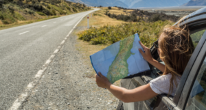 a photo of a woman pulled over on the side of the road looking at a map
